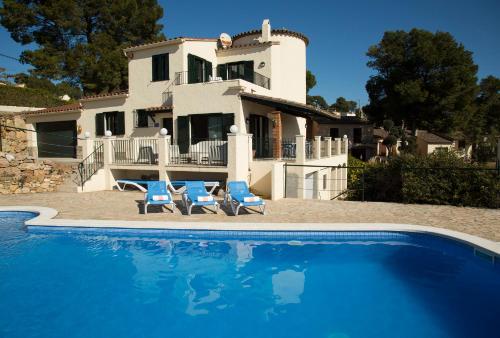 eine Villa mit einem Swimmingpool vor einem Haus in der Unterkunft Torre Orquidaceae - Plus Costa Brava in L'Estartit