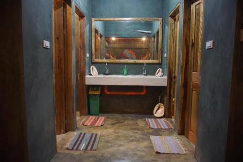 a bathroom with a sink and a mirror at Hiraya Surf Hostel in General Luna