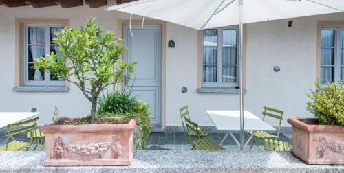 a patio with a table and chairs and an umbrella at Villa Edy Apartments in Tremezzo