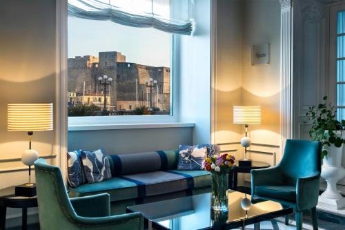 a living room with a couch and chairs and a window at Grand Hotel Santa Lucia in Naples