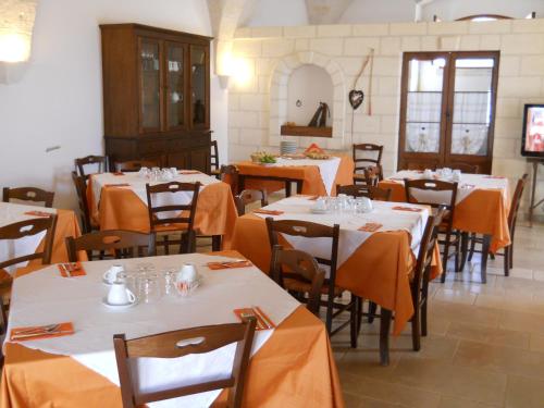 una sala da pranzo con tavoli e sedie con panna arancione di Masseria De Michele a Montalbano
