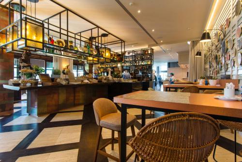 Un restaurante con mesas y sillas y un bar. en Lindner Hotel Mallorca Portals Nous, part of JdV by Hyatt, en Portals Nous