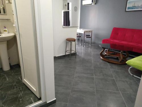 a living room with a red couch and a table at Apartment Eteri in Batumi
