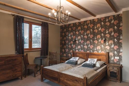 ein Schlafzimmer mit einem Bett und einer Wand mit Blumen in der Unterkunft Góralski Dwór in Duszniki-Zdrój