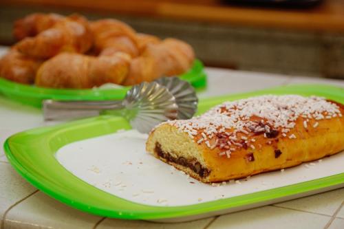 a piece of cake on a green plate with a fan at B&B Villa Maria in Agropoli