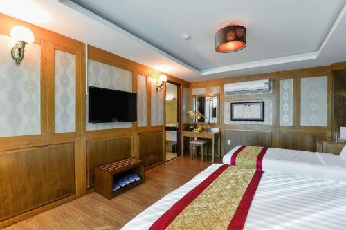 a bedroom with a bed and a flat screen tv at Saigonciti Hotel A in Ho Chi Minh City