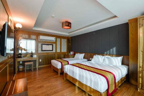 a hotel room with two beds and a television at Saigonciti Hotel A in Ho Chi Minh City
