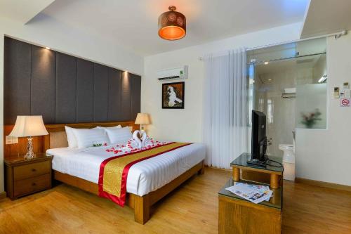 a bedroom with a bed and a television in it at Saigonciti Hotel A in Ho Chi Minh City