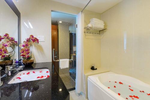 ein Badezimmer mit einer Badewanne und einem Waschbecken in der Unterkunft Saigonciti Hotel A in Ho-Chi-Minh-Stadt