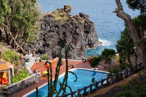 a resort with a swimming pool next to the ocean at Aldeia da Fonte Hotel in Lajes do Pico