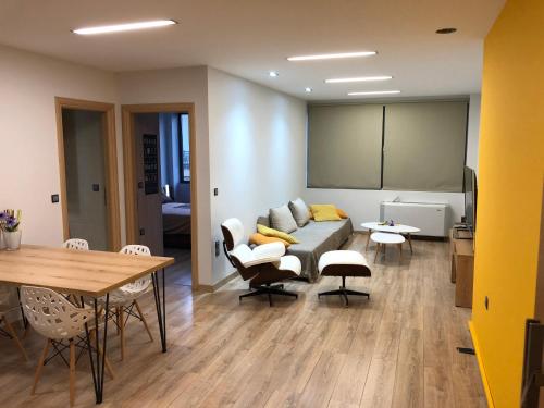 a living room with a couch and a table and chairs at URBAN APARTMENT in Amaliás