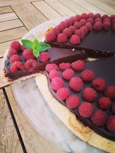 Een chocoladedessert met frambozen op een bord. bij La Locanda del Priore in Vale