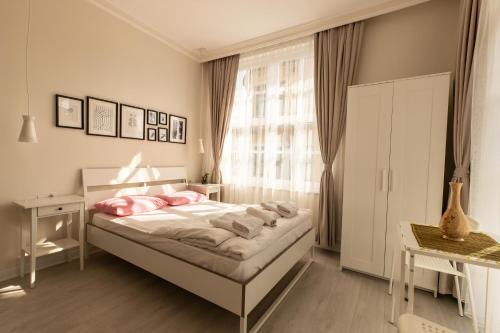 a bedroom with a bed with pink pillows and a window at ATICI HOTEL in Antalya