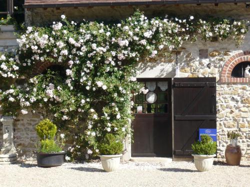 a bush with white flowers in front of a door at La Petite Ferme in Vouzeron
