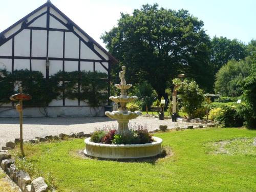 a fountain in the middle of a park with a building at La Petite Ferme in Vouzeron