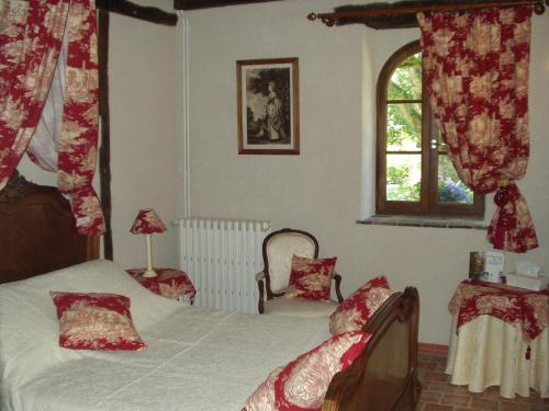 a bedroom with a bed and a window at La Petite Ferme in Vouzeron