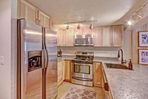 a kitchen with a stainless steel refrigerator and a sink at Cm116 Copper Mtn Inn Condo in Copper Mountain