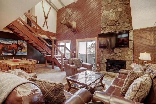 a living room with leather furniture and a stone fireplace at Cm416 Copper Mtn Inn Condo in Copper Mountain