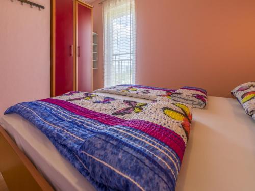 a bedroom with a bed with a quilt on it at Dolores in Crikvenica