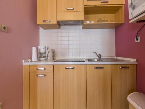 a small kitchen with wooden cabinets and a sink at Dolores in Crikvenica