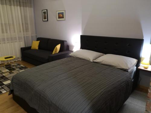 1 dormitorio con 1 cama grande y 1 sofá en Apartman Loen, en Zagreb