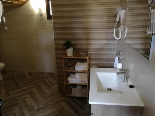 a bathroom with a white sink and wooden floors at Apartamento La Sierra in La Codosera