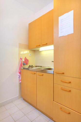 a kitchen with wooden cabinets and a stove at Pension Villa Stella in Špindlerův Mlýn