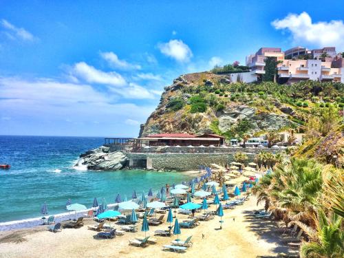plaża z leżakami i parasolami oraz ocean w obiekcie M&N Luxury Family Apartment 10meters from the Sea w mieście Agia Pelagia