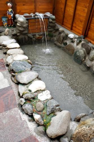 a pond with rocks and a waterfall in a yard at 依比鴨鴨水岸會館 Ducking House in Ruisui