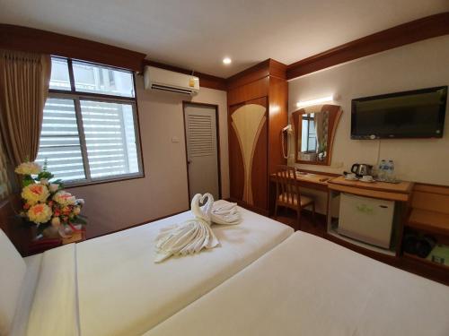 a bedroom with a white bed with a desk at Sakol Hotel in Hat Yai