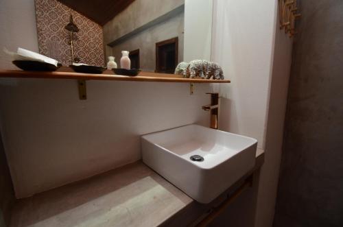 a white sink in a bathroom with a shelf at Moonlight Champa Riverview in Luang Prabang