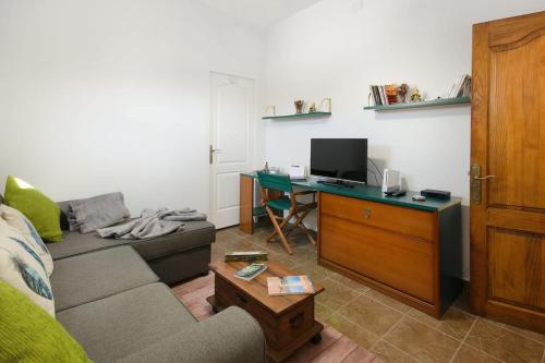 a living room with a couch and a desk with a computer at Buda in Tinajo