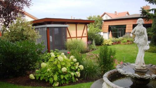ヘリングスドルフにあるGartenhaus Dassowの庭に像と花を植えた庭園