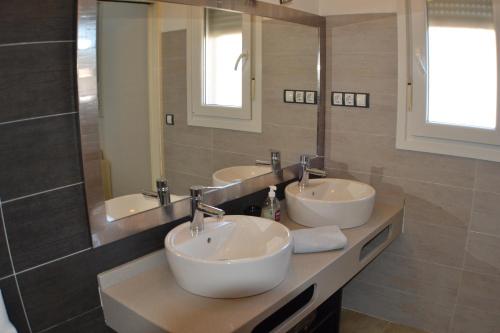 エル・ポソ・デ・ロス・フライレスにあるCasas Maria Carmonaの洗面台3つと鏡付きのバスルーム