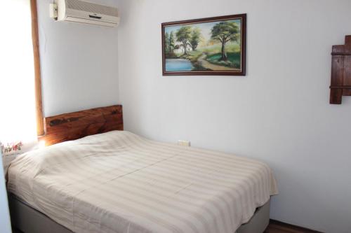 a white bedroom with a bed with a picture on the wall at Tuncay Pension in Selçuk