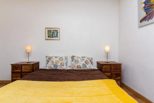 a bedroom with a large bed with two night stands at Lisbon South Bay Rooms in Amora