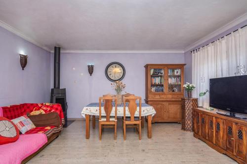 a living room with a table and a tv at Lisbon South Bay Rooms in Amora