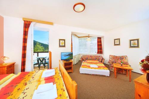 ein Schlafzimmer mit 2 Betten und ein Wohnzimmer in der Unterkunft Pension Villa Stella in Špindlerův Mlýn