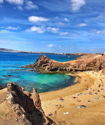 a beach with a group of people in the water at Buda in Tinajo