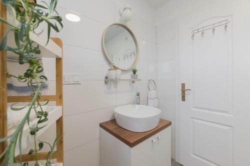 a white bathroom with a sink and a mirror at Apartmani Zara in Zaton