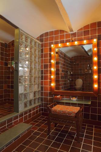 a bathroom with a mirror and a bench in it at The House of MG-A Heritage Hotel, Ahmedabad in Ahmedabad