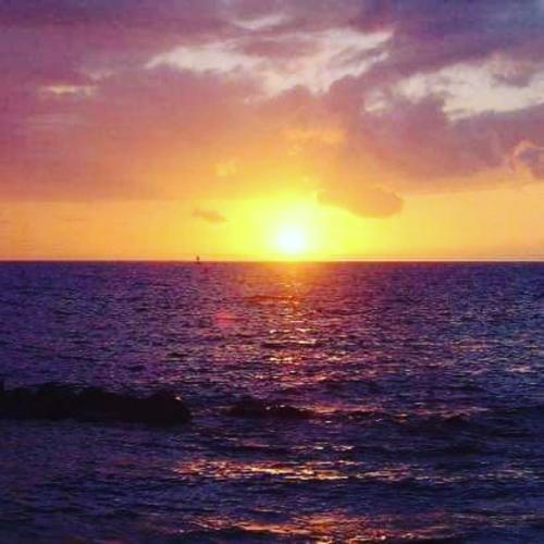 a sunset over the ocean with the sun setting at Buda in Tinajo