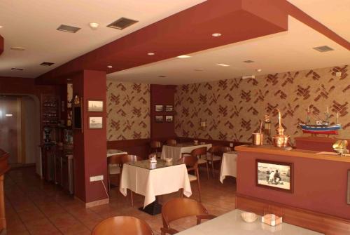 a restaurant with tables and chairs in a room at Hotel El Pescador in Perillo