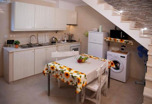 a kitchen with a table and a washing machine at A Casa dos Girassóis in Cuba