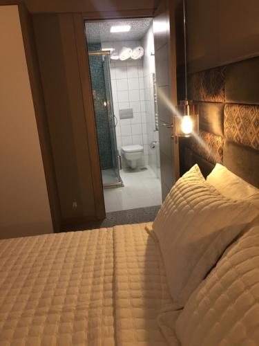 a bedroom with a large bed and a bathroom at ACR PALAS in Edirne