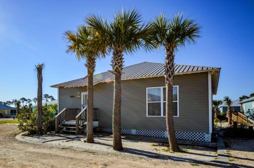 a house with palm trees in front of it at The Rookery III Unit 7024 Cottage in Gulf Shores