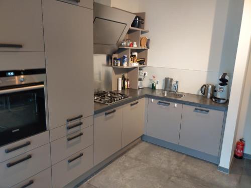 una cucina con armadi bianchi e piano cottura di Appartement boerderij met paarden a Oost-Souburg