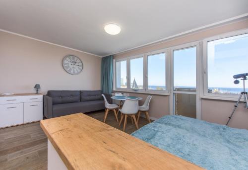 - une chambre avec un lit, une table et un canapé dans l'établissement Avis Apartments - Gdynia Skwer Kościuszki, à Gdynia