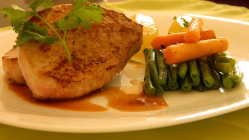 a plate of food with meat and vegetables on a table at Hotel Restaurant L Echo du Lac in Gérardmer