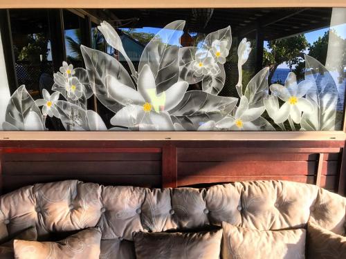 a window display with white and blue flowers at Robinson's Cove Villas - Deluxe Wallis Villa in Papetoai